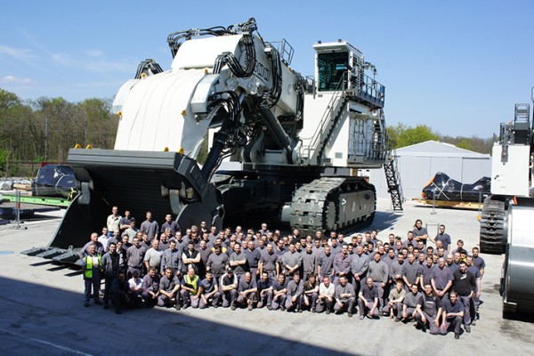 Des collaborateurs à Colmar (France) devant la plus grande pelle minière de Liebherr