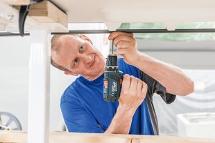 Un collaborateur monte le fond d'un congélateur de supermarché Liebherr.