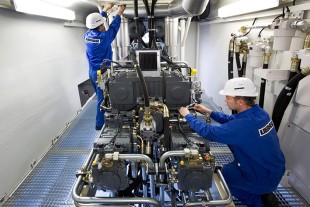 Liebherr specialists in the engine room of mobile harbor crane during the test phase