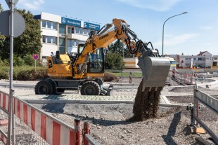 Wheeled excavator A 910 Compact deployed in inner city road works