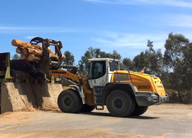 The industrial lift arm of Dormit’s Liebherr L 550 wheel loader is ideal for working with heavy equipment, such as the log grapple for transporting tree trunks.