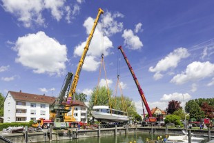 An LTM 1350-6.1 and an LTM 1400-7.1 launch a 100 tonne ship's hull into the water by tandem hoist.