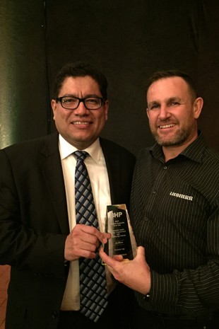 Edgar Basto (BHP Asset President of WA Iron Ore) presenting the award to Anthony Piggott (Liebherr Perth Field Service Supervisor).