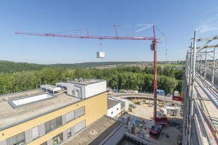 MK 140 Liebherr mobile construction crane exchanging air conditioners at a hospital in Heidenheim.