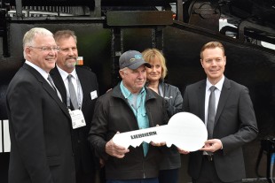 Stephen Vinot, center, operations manager for SKV Crane and Rigging, celebrates the handover of the LR 1800 with Liebherr staff at the company’s Conexpo booth.